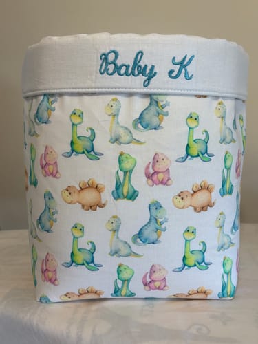 Customer's Watercolor Cartoon Dinosaurs Fabric used to make a personalized storage basket embroidered with 'Baby K'.