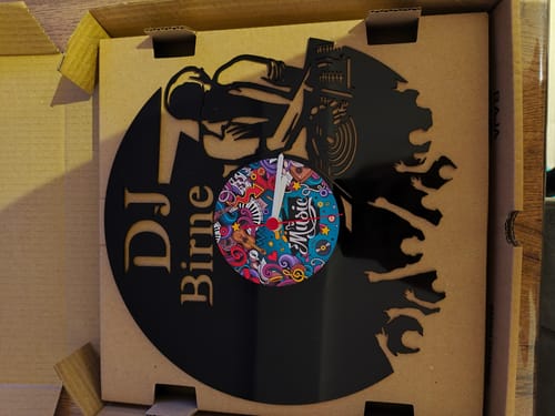 Ein Kunde zeigt die personalisierte DJ-Vinyl-Wanduhr mit dem Namen 'DJ Birne' in der Originalverpackung.