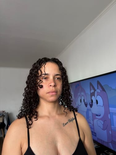 Cliente montrant ses boucles définies et brillantes après avoir utilisé la Double Gelée Deep Blue Radiance.