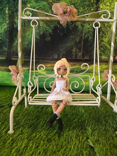Customer's doll sits on a miniature swing wearing the white Meki Creators' Suspender Dress.