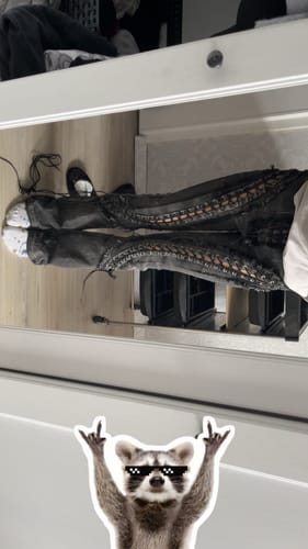 Reviewer in a mirror photo wearing the black denim LOW RISERS with full-length leg lacing.