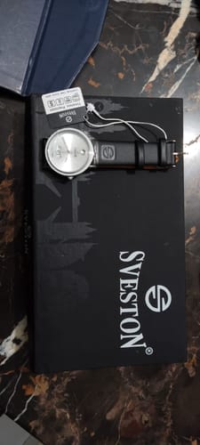 Customer's new Aspire watch with a black leather strap, shown resting on top of its black Sveston box.