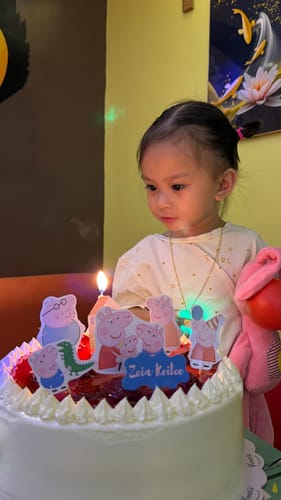 Customer's image of a young child looking at a birthday cake.