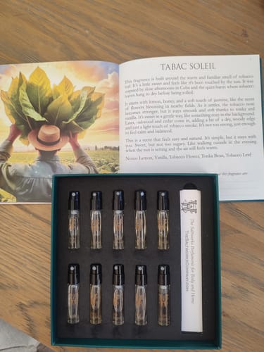 Customer's Discovery Set displayed open, showing ten sample vials in a box beside the illustrated booklet.