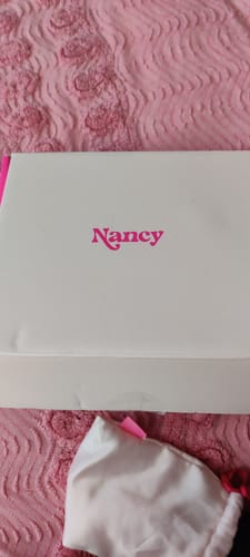 Customer showing the white box and storage pouch for the Lem Clitoral Massager on a pink surface.
