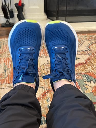 Customer's point-of-view shot of their new blue Flow Wide Toe Box Pickleball Shoes being worn indoors.