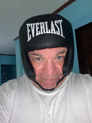 Close-up of a reviewer wearing the black Everlast Core Boxing Headgear, showing its fit.