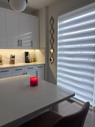 Customer's wavy gold teardrop mirror hung vertically on a narrow kitchen wall.