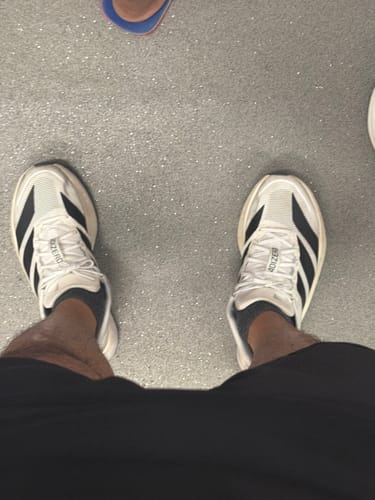 Customer's top-down view wearing the white and black Adizero Boston 13 running shoes.