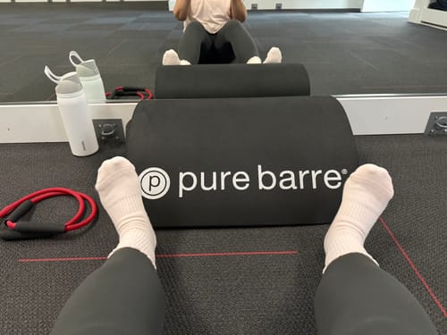 Reviewer's first-person view of their soft pink Dual-Direction Grip Basics socks in a fitness studio.