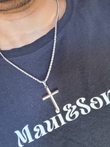 Primer plano de un cliente usando el colgante Crucifijo con su cadena tipo cuerda.