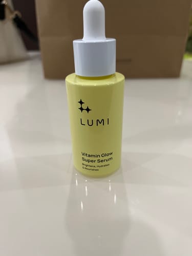 Customer's Vitamin Glow Super Serum in a yellow bottle with a white dropper, placed on a white surface.