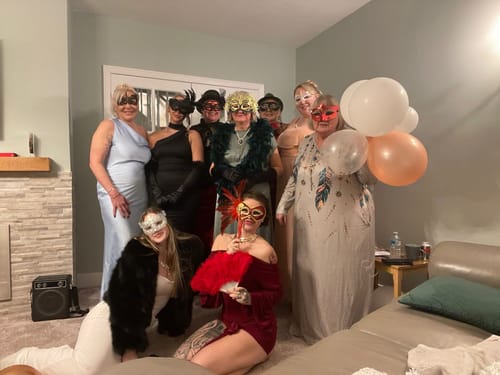 Customers in masquerade masks and elegant gowns posing together while playing the Murder Mystery Game Kit.