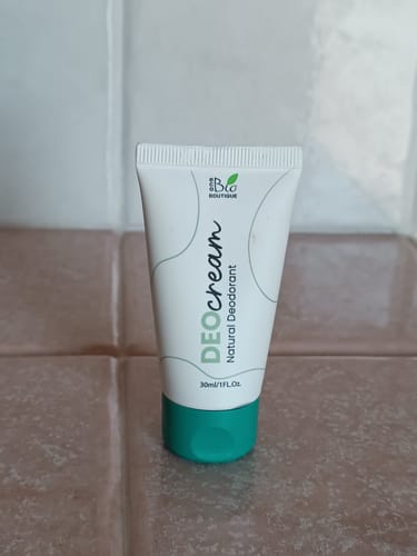 Recensore mostra il tubetto bianco del deodorante DeoCream con tappo verde.
