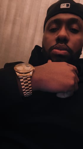 Customer resting their hand on their chin, showcasing a gold-colored watch.