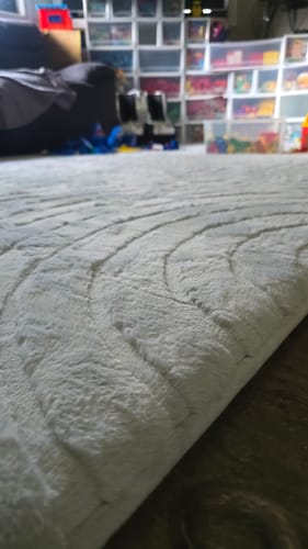 Customer's close-up of the soft, grey Relax Mat in a child's playroom, highlighting its texture.