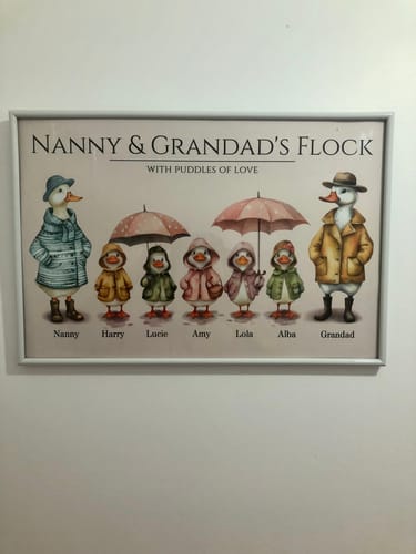Customer's framed and personalised watercolor duck poster, 'Nanny & Grandad's Flock,' hanging on a wall.