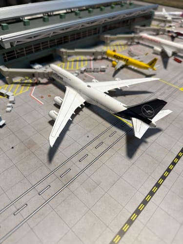 Customer's Gemini Lufthansa 747-8 model airplane on a detailed model airport tarmac.