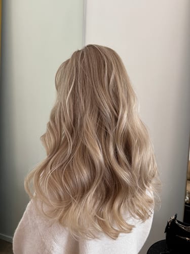 Reviewer showing the results of the Sunkissed Starter Kit on their long, wavy blonde hair.