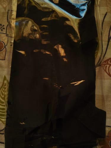 Customer's black Frido Orthotics Posture Corrector inside its clear plastic packaging.