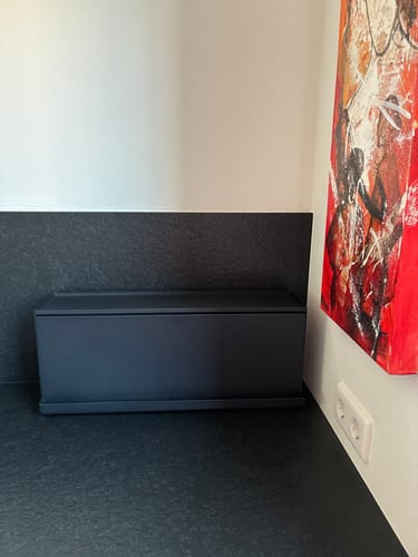 Recensent toont de zwarte Yamazaki aanrecht organizer op een donker aanrecht.