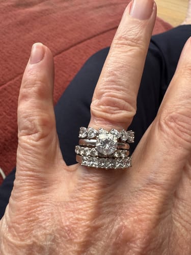 Customer's hand showing the HEART CUT BAND RING stacked with other diamond rings.