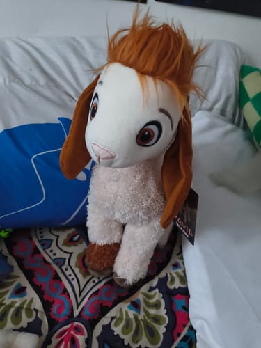 Customer's Tali Plushie with soft white fur and orange hair sitting on a bed.