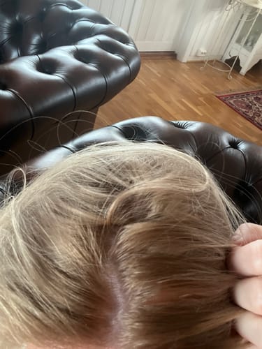 Close-up of a customer's hair showing brassy, orange roots after using the Sunkissed Starter Kit.