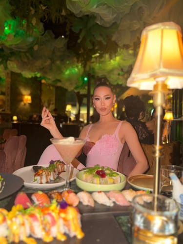 Reviewer wearing the pink Naked Rose Tank Bodysuit while dining at a restaurant.