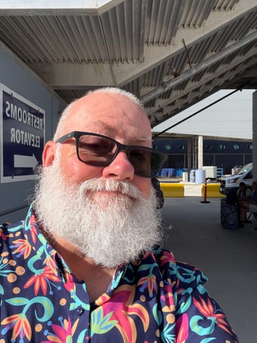 Close-up of a reviewer wearing the vibrant, floral Rogue Foliage shirt.