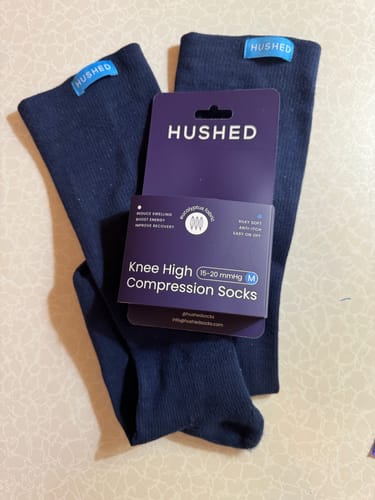 Customer's new Performance Eucalyptus Compression Socks displayed in their original purple packaging.