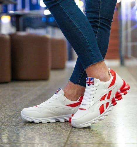 Reviewer wearing the white Ortho Step 2.0 sneakers with red accents and a distinct wavy sole.