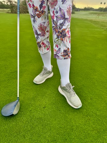 Reviewer standing on a golf course wearing white Performance Eucalyptus Compression Socks.