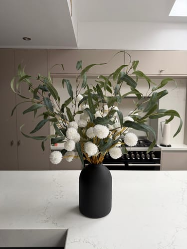 Customer's black Arlo Vase with a large floral arrangement on a kitchen counter.