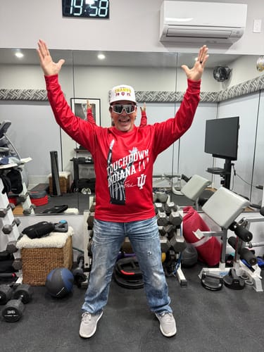 Reviewer in a gym wearing the front of a custom red pullover with a 'Touchdown Indiana' graphic.