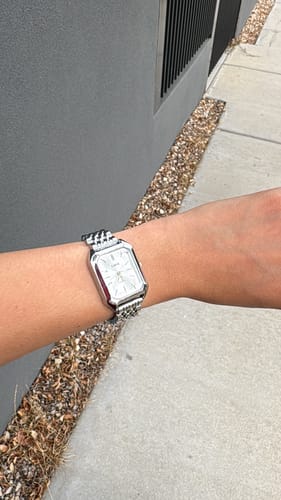 Reviewer wearing the silver-colored CLAIRE DE MAINS watch on their wrist outdoors.