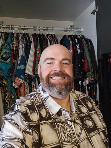 Customer wearing the sketch-style How Ya Doin' Bamboo Short Sleeve Shirt in front of a closet full of shirts.