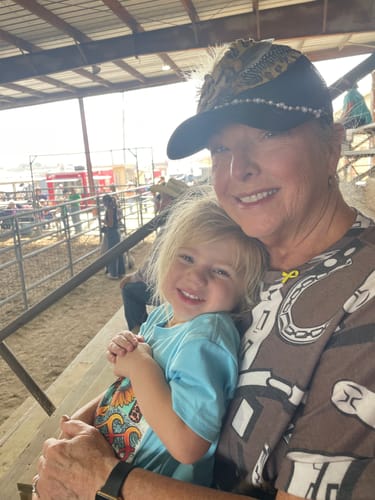 Reviewer with healthy skin smiling and holding a young child after using the Seranova Micro Infusion System.