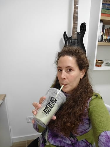 Una clienta bebe de un vaso reutilizable con una pajita, incluido en el Pack Experiencia Iniciación.