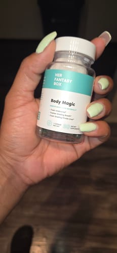 Reviewer holds a clear bottle of Body Magic Chlorophyll Pills, showing the capsules inside.