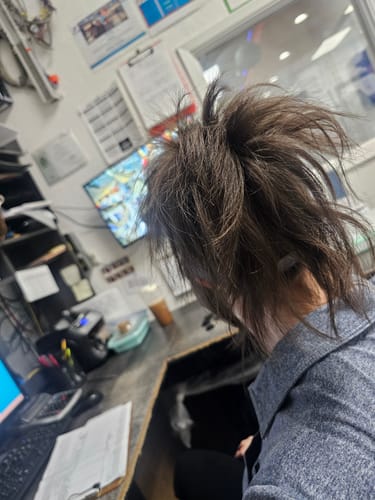 Reviewer with their brown hair held up in a messy style by the cloud clip.