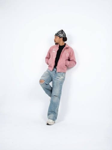 Reviewer leans against a wall wearing the pink Suede Embroidered Zippered Short Jacket.