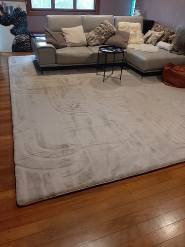 Customer's large, light-colored Mellow Mat with a carved pattern laid out in a living room.