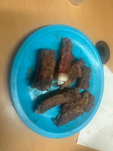 Cliente muestra los distintos cortes cocinados del Kit Cortes Finos en un plato azul.