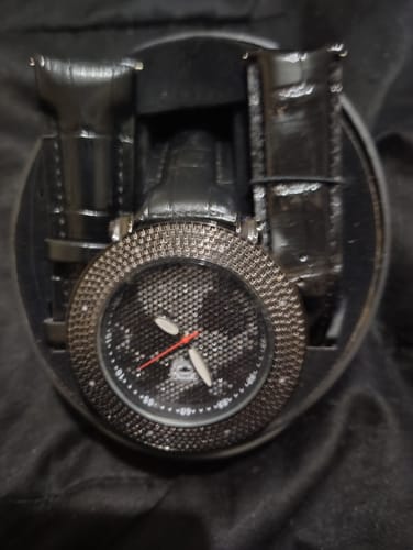 Customer's black World Map Dial Watch shown in its display case with two extra bands.