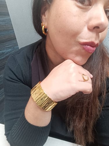 Una clienta muestra de cerca sus pendientes Soho Hoops Mixed dorados.