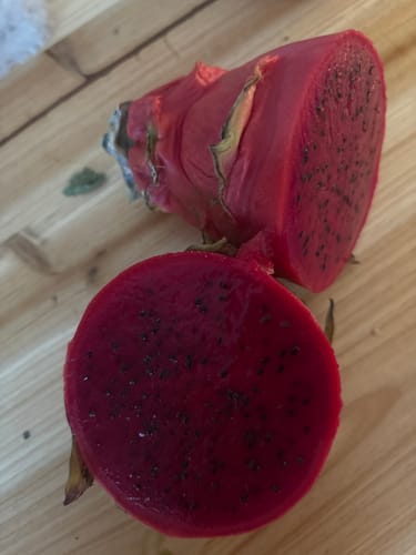 Reviewer's Red Dragonfruit cut open, showing the vibrant red flesh full of black seeds.