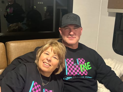 A reviewer and another person smiling while sitting together on a couch.