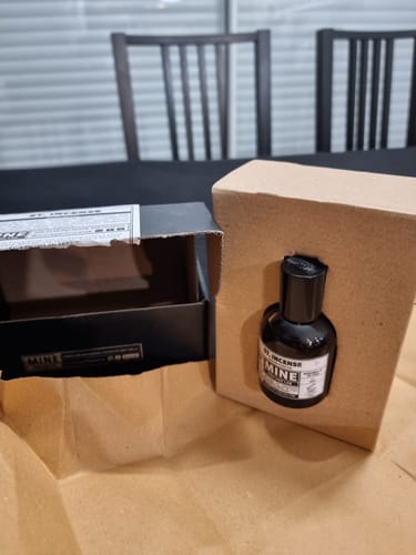 Recensore che mostra il profumo ST INCENSE parzialmente fuori dalla sua confezione nera su un tavolo.