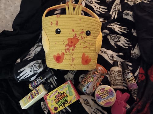 Reviewer displays the yellow, spooky Chicks from the Crypt Basket with all the included body care products and candy.